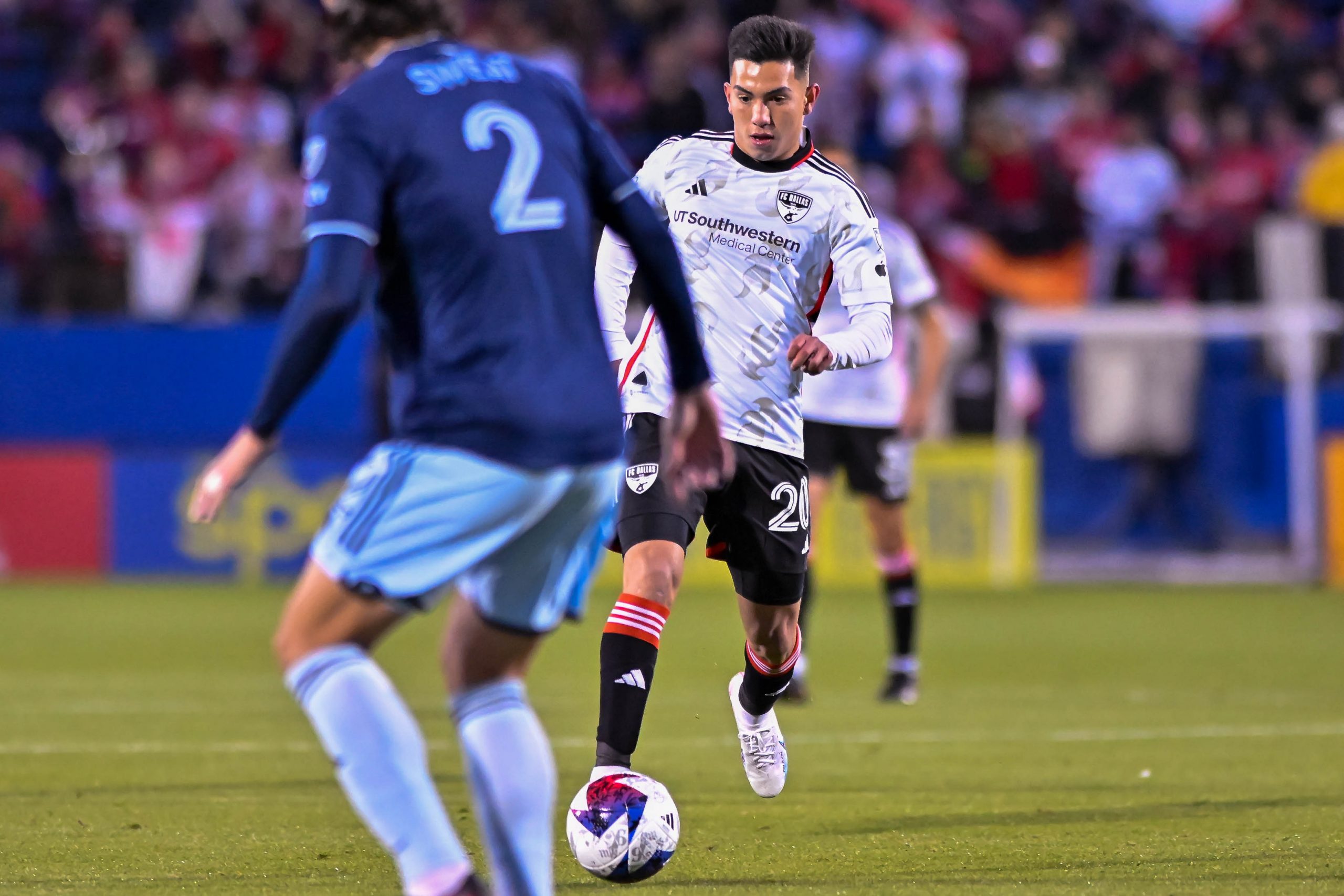 Alan Velasco dribbles toward Sporting KC defender Ben Sweat in the MLS match on Saturday, March 18, 2023, at Toyota Stadium. (Daniel McCullough, 3rd Degree)