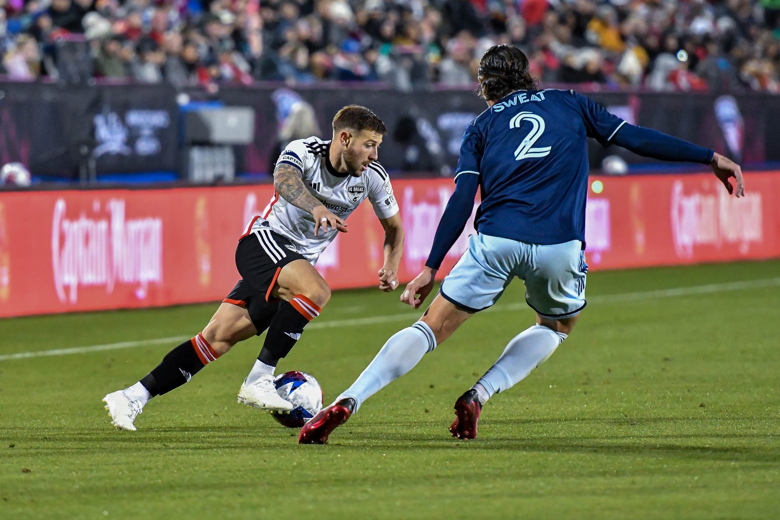 Paul Arriola dribbles past Sporting KC defender Ben Sweat in the MLS match on Saturday, March 18, 2023, at Toyota Stadium. (Daniel McCullough, 3rd Degree)