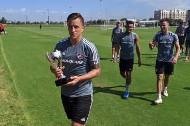 Reto Ziegler proudly walks off the FC Dallas training field with the championship trophy in hand after his team won the 6-man small side competition at the end of training. (9-25-19)(3rd Degree / Buzz Carrick)