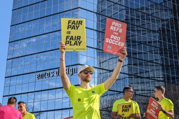 2022 FIFA World Cup assistant referee Kyle Atkins holds yellow and red cards at a picket in Dallas (Dan Crooke)