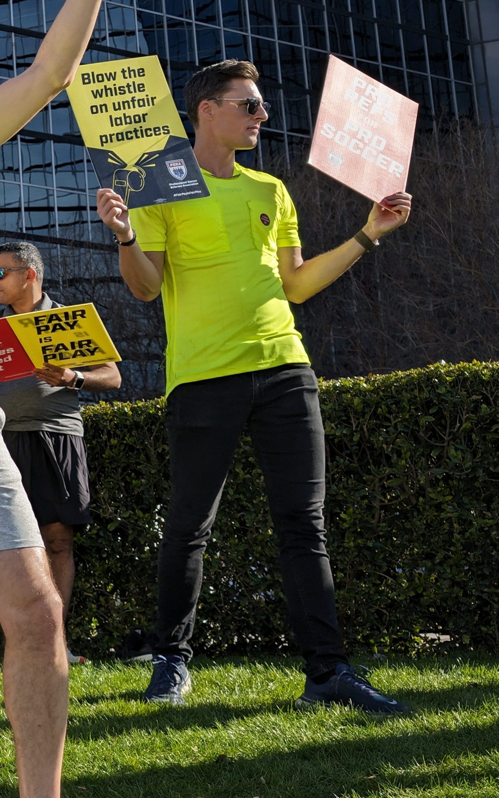 MLS referee Joe Dickerson holds yellow and red cards at a picket in Dallas (Dan Crooke)