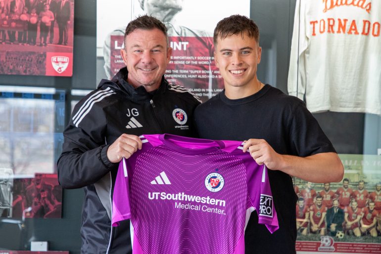 JT Harms (right) signs with North Texas SC and holds up a keeper kit with NTSC Head Coach John Gall. (Courtesy North Texas SC)