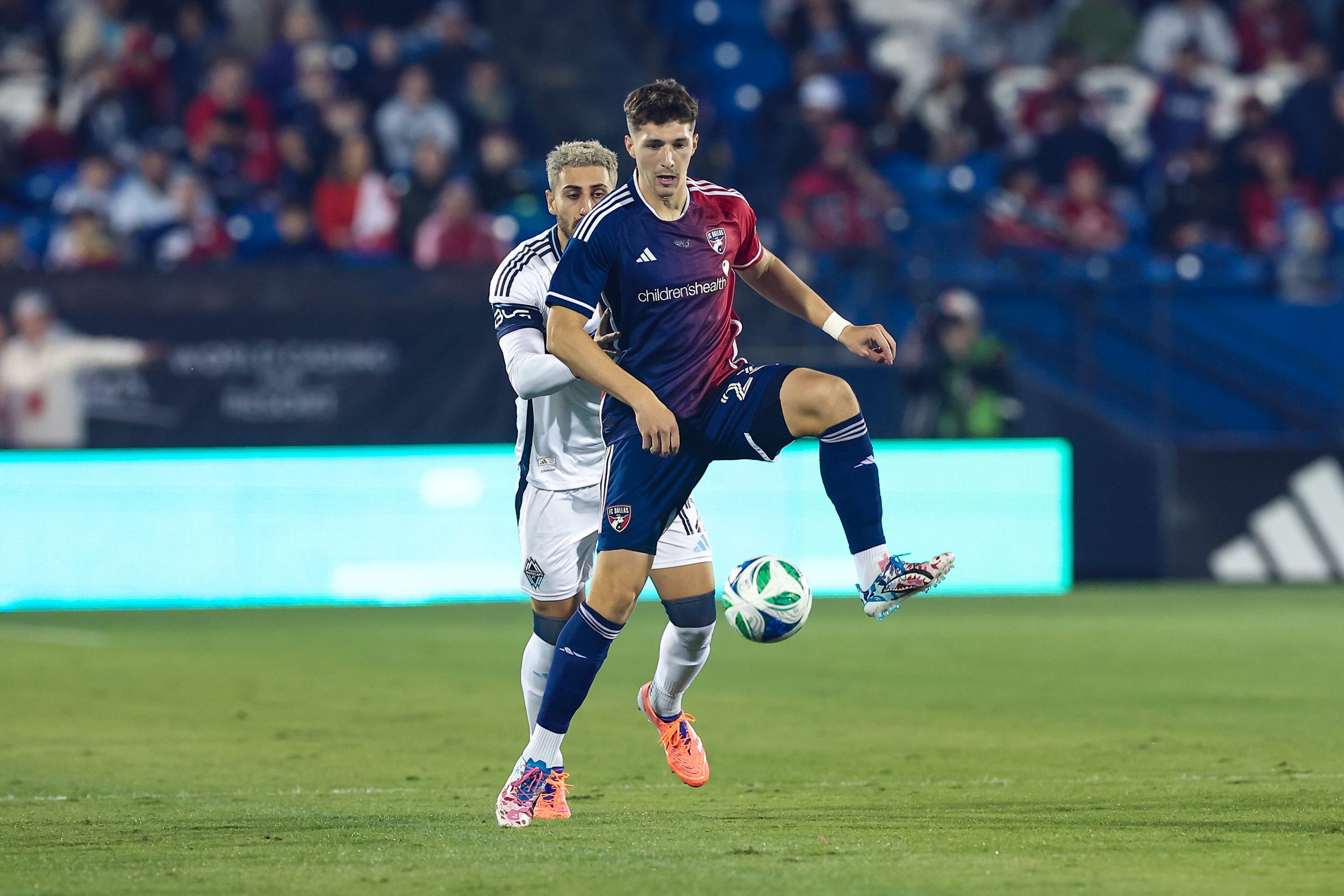 Logan Farrington holds the ball against Vancouver Whitecaps defense in the MLS Cup Playoff game 2, November 1, 2025. (Matt Visinsky, 3rd Degree)