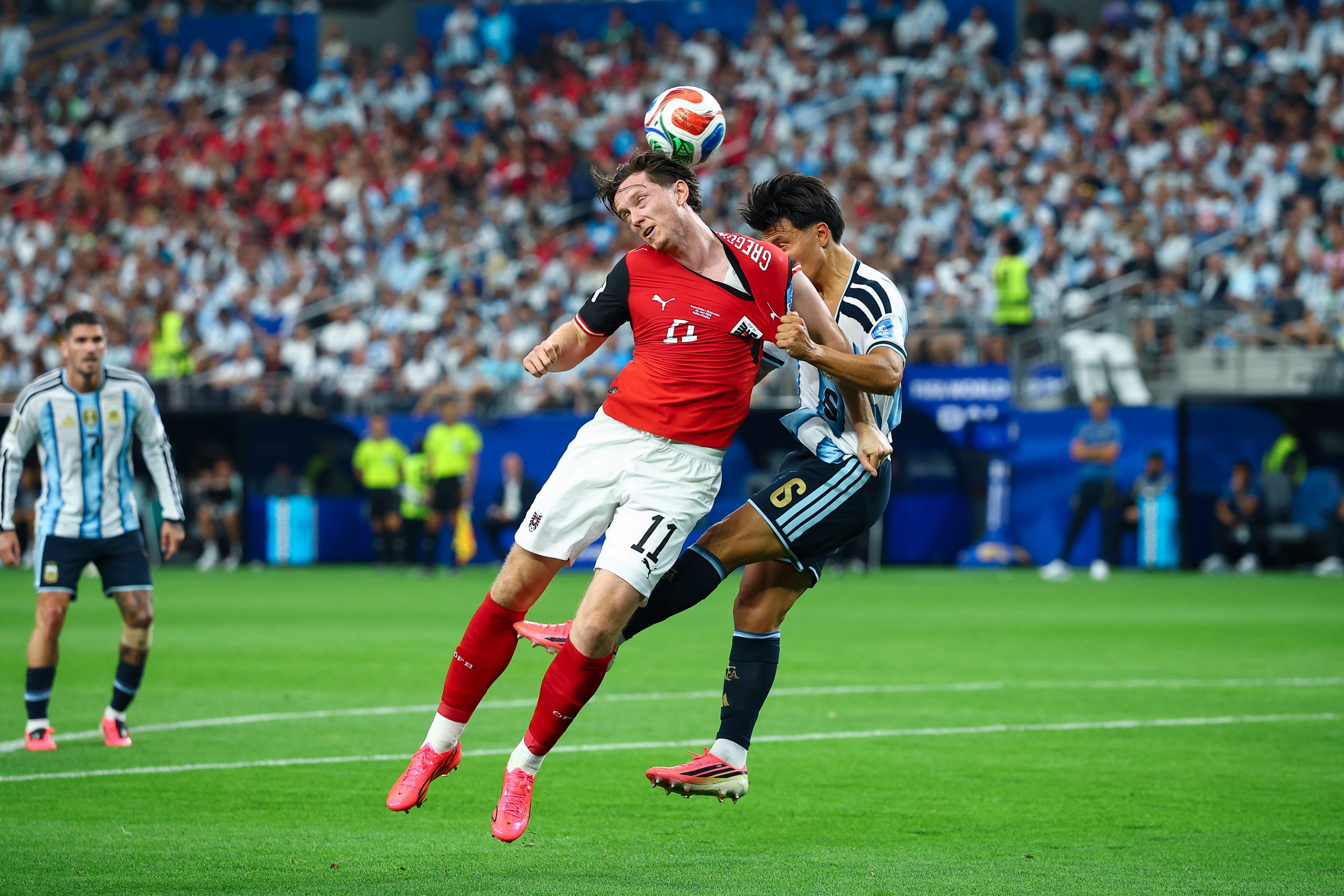 Michael Gregoritsch (11) battles Lisandro Martínez (6) in an aerial duel. Argentina vs Austria, World Cup 2026, June 22, 2026. (Matt Visinsky, 3rd Degree)