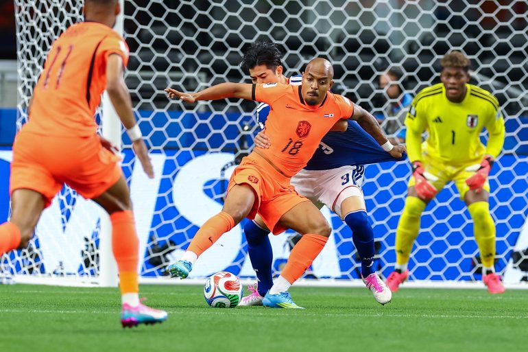 Donyell Malen (18) fends off Shogo Taniguchi(3). Japan vs Netherlands, at "Dallas Stadium," 2026 World Cup, June 14, 2026. (Matt Visinsky, 3rd Degree)