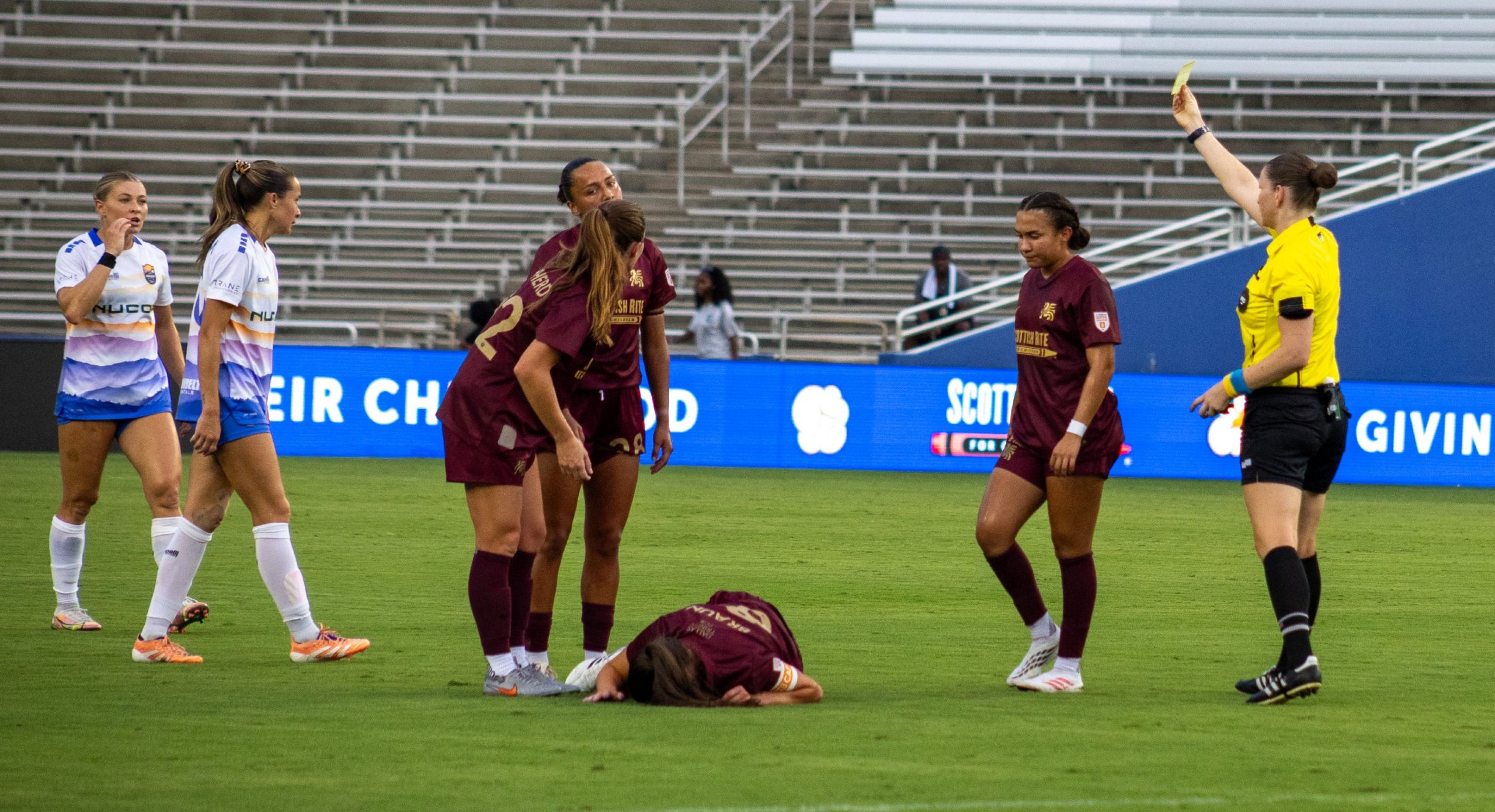 Sophie Braun (8) is down after contact while a yellow card is given. Dallas Trinity vs Carolina Ascent, August 22, 2026. (Beth Spicer, 3rd Degree)