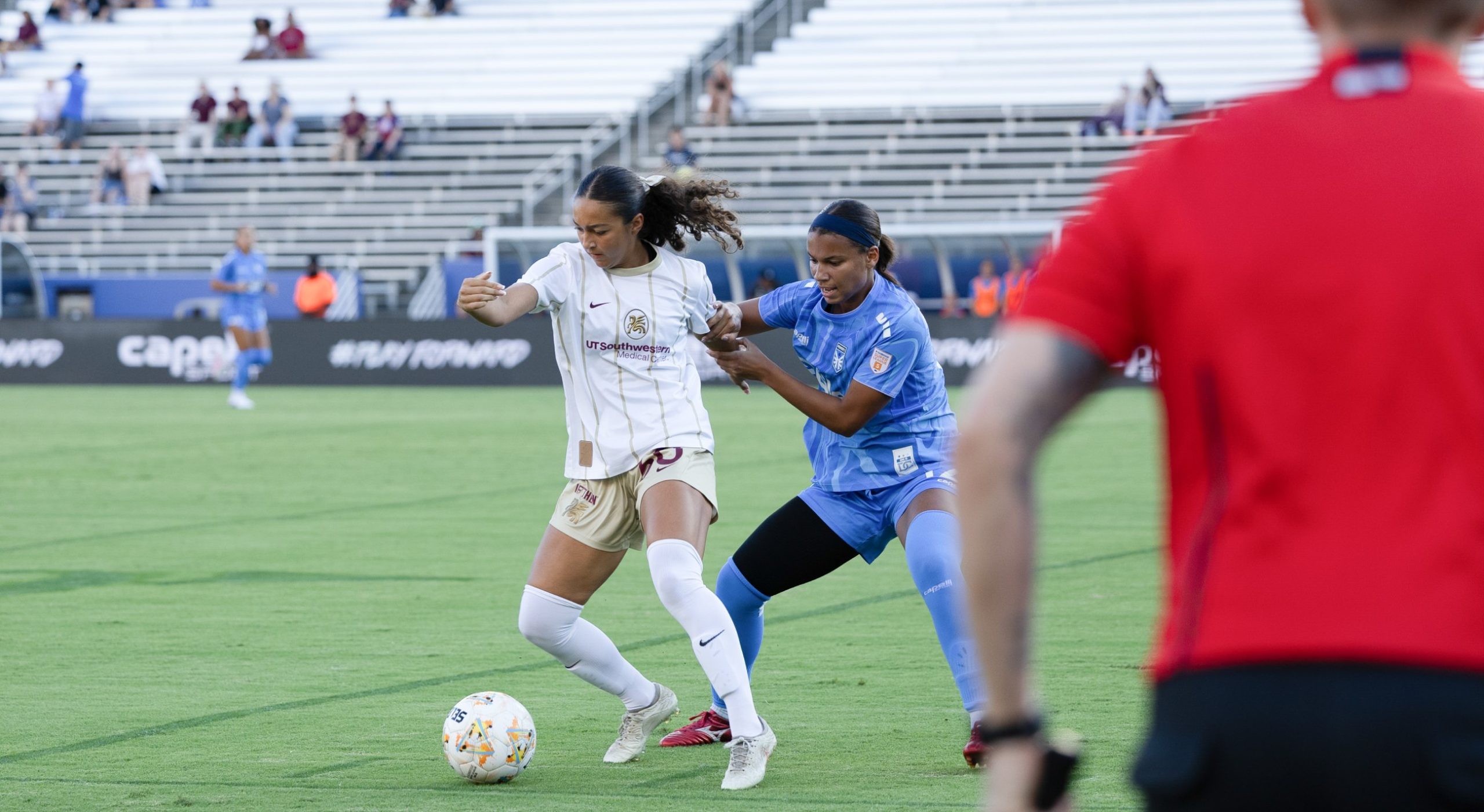 Seven Castain (30) fights off a defender as the assistant referee looks on. Dallas Trinity takes on DC Power, September 13, 2026. (Beth Spicer, 3rd Degree)